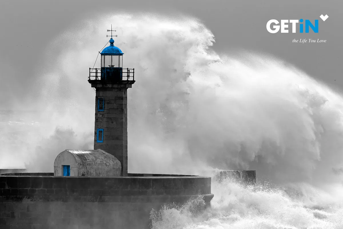 GETiN — GETiN logo over a black-and-white photo of a lighthouse struck by a wave