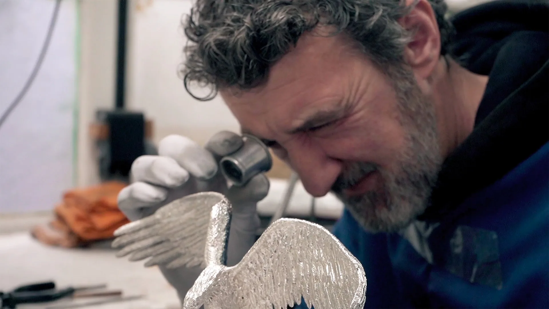 Leitão & Irmão – Benfica 118 Anos — video still of a craftsman inspecting a silver eagle sculpture