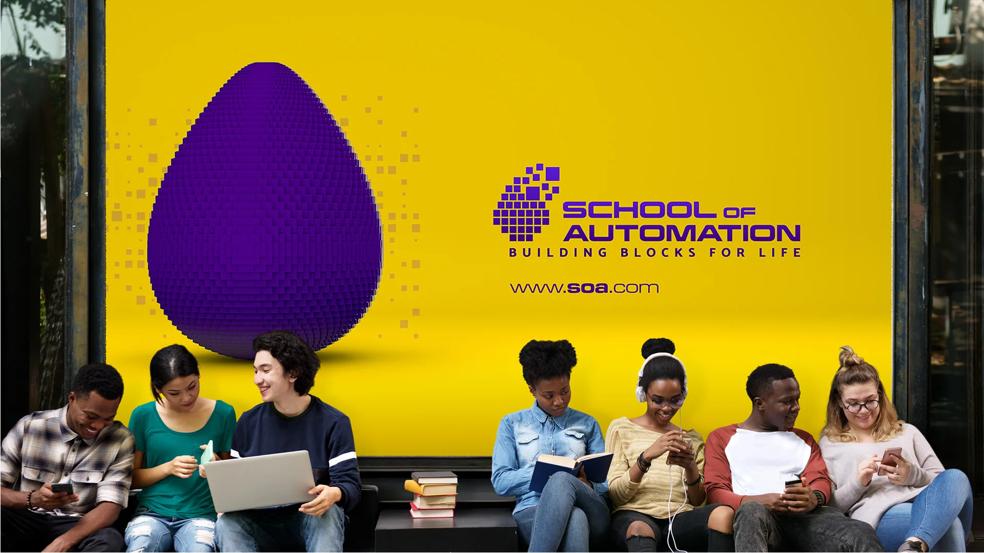 SOA – School of Automation — yellow billboard with purple pixel egg and logo above students sitting with books