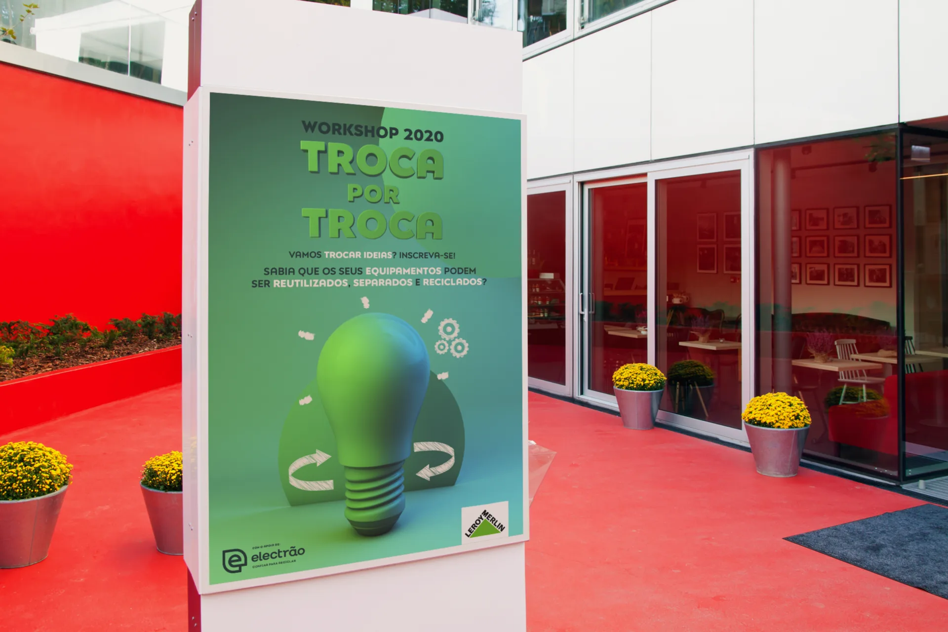 Tempo de Reciclar — "Troca por Troca" workshop poster on an outdoor stand by a storefront